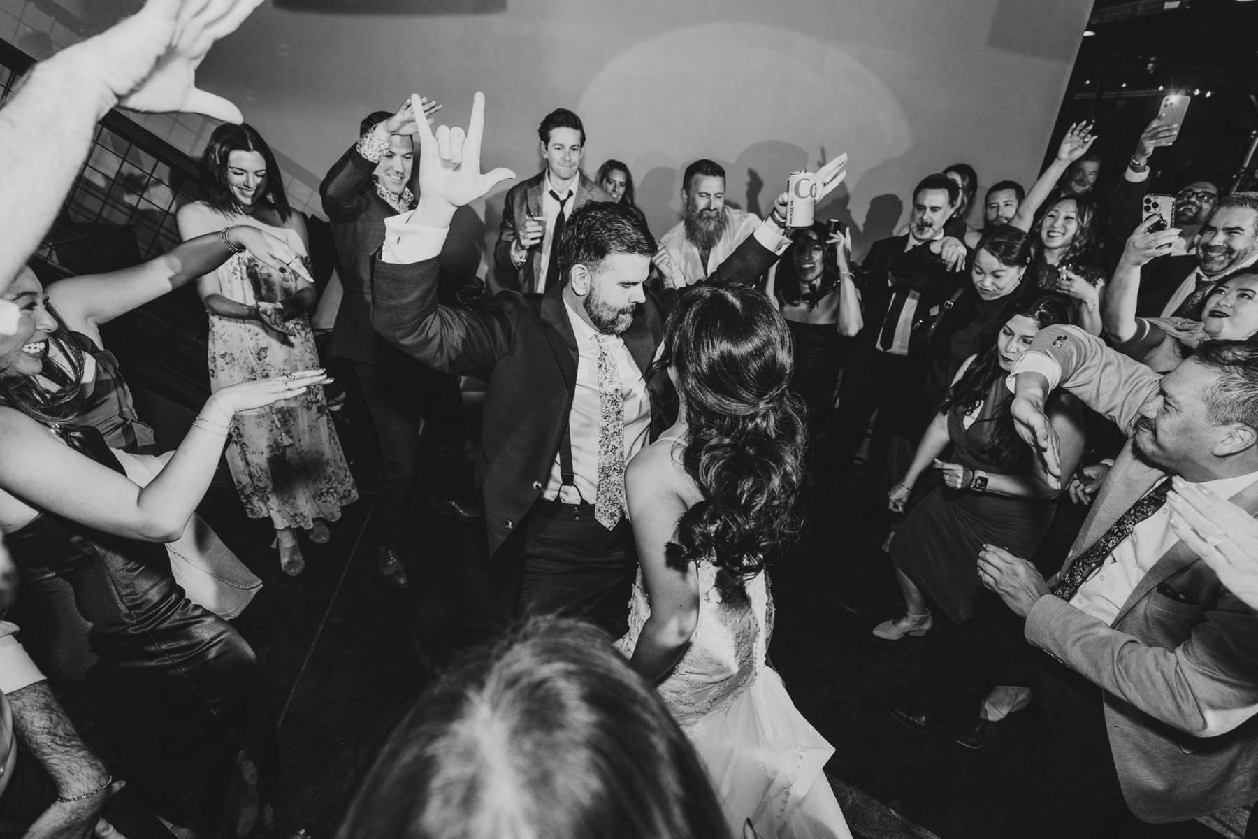 The groom dancing in the middle of a circle of cheering guests