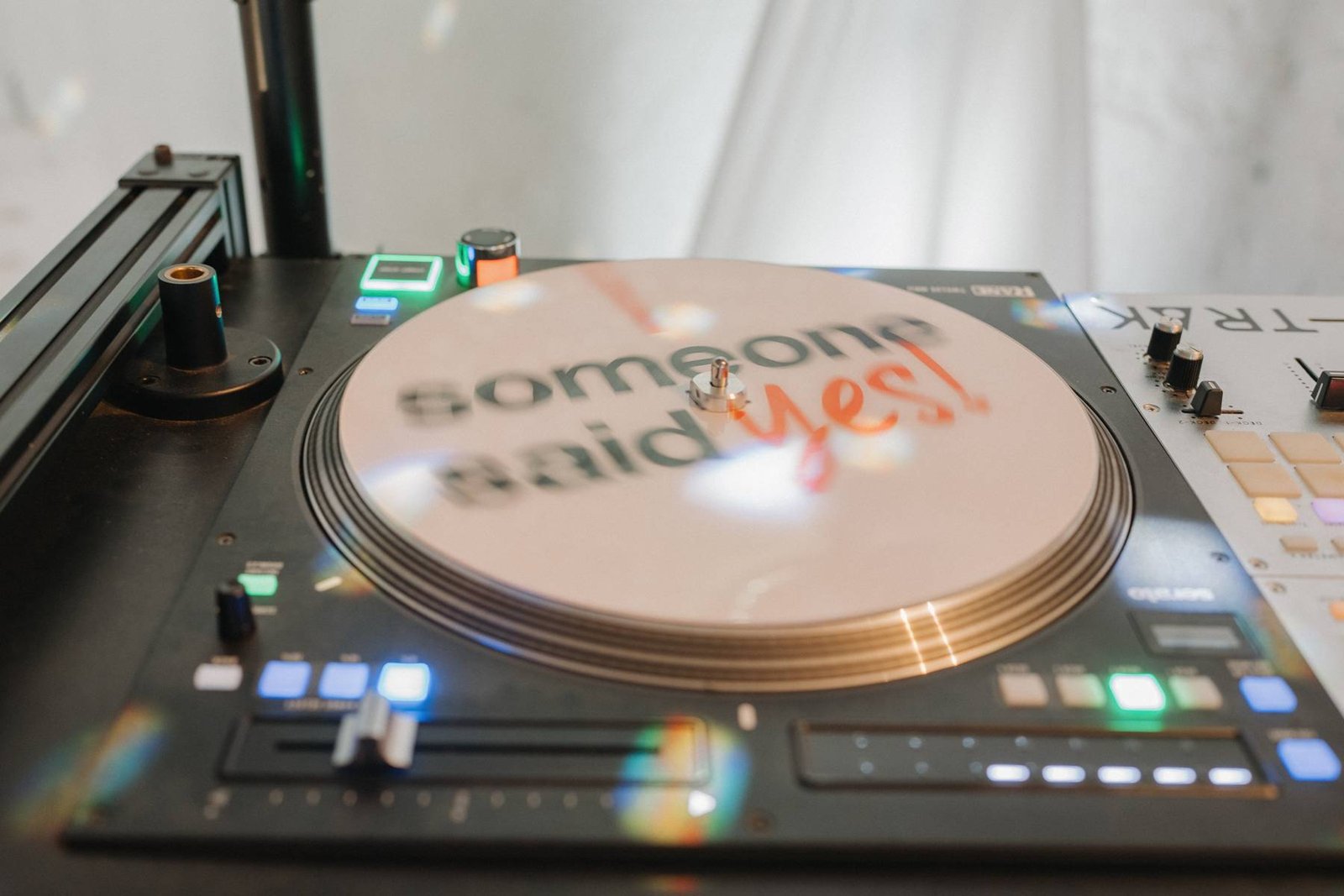 Close up of a turntable spinning a slipmat, with soft light and rainbow flares across the deck